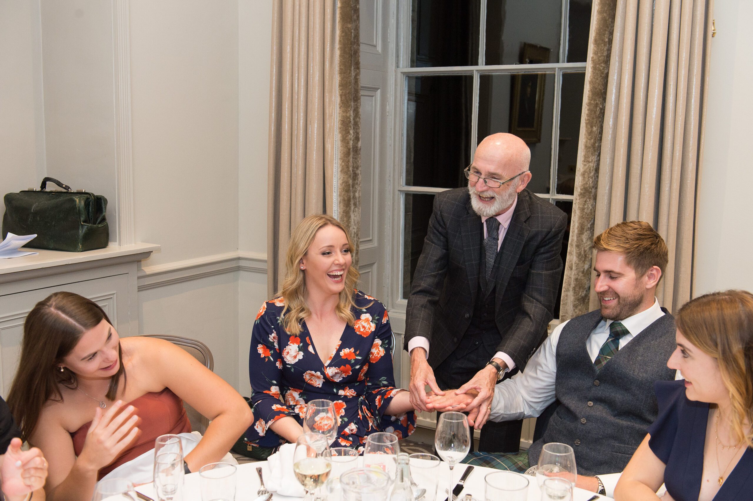 couple at newly wed reception enjoyng a magic trick